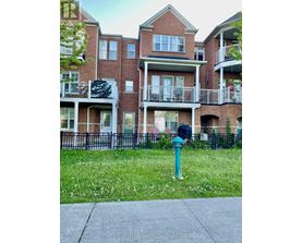 A brick apartment building with a green lawn in front.