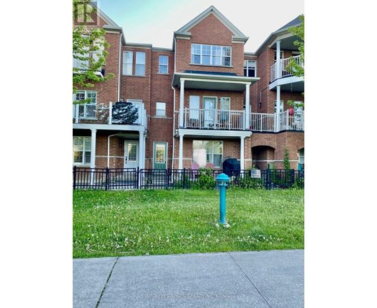 A brick apartment building with a green lawn in front.