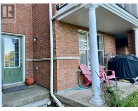 A red brick house with a green door and a sign that says REALTOR.