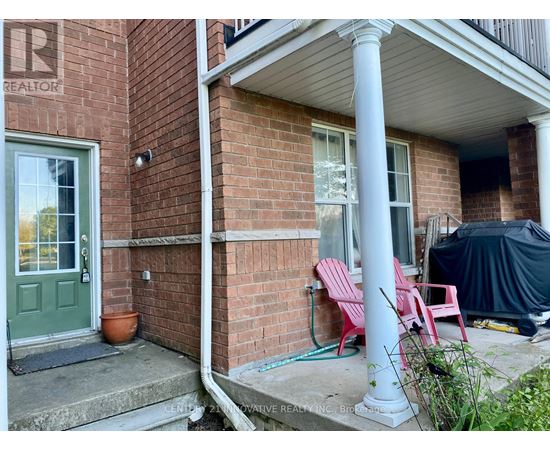 A red brick house with a green door and a sign that says REALTOR.