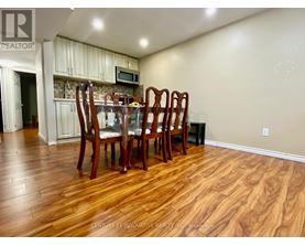 A dining room with a wooden table and chairs.