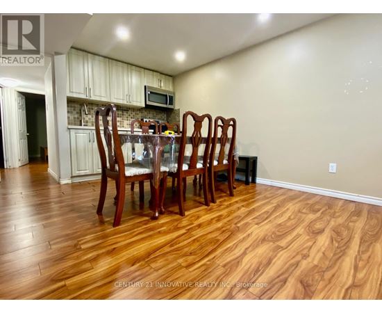 A dining room with a wooden table and chairs.