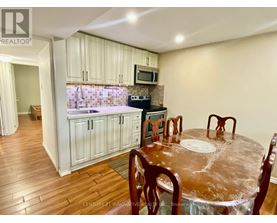 A kitchen with wooden floors and a dining table set for four.