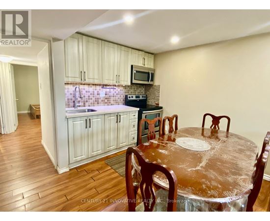 A kitchen with wooden floors and a dining table set for four.