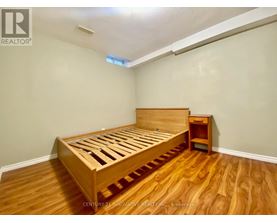 A bedroom with a wooden bed and nightstand.