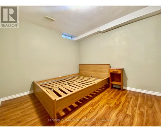 A bedroom with a wooden bed and nightstand.