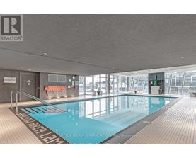 A large indoor swimming pool with a wooden floor and a glass wall.