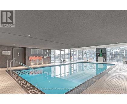 A large indoor swimming pool with a wooden floor and a glass wall.