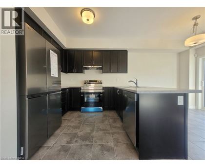 A kitchen with black cabinets and a tiled floor.