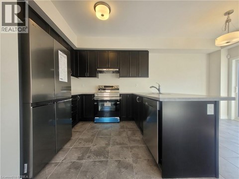 A kitchen with black cabinets and a tiled floor.