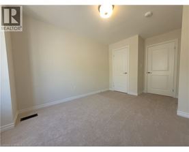 A bedroom with two doors and a carpeted floor.
