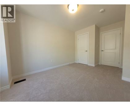 A bedroom with two doors and a carpeted floor.