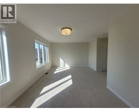 A spacious room with a window on the left and a door on the right.