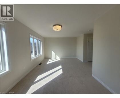 A spacious room with a window on the left and a door on the right.