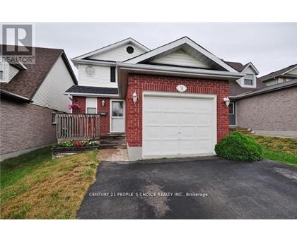 A house with a red brick facade and a white garage door is for sale.
