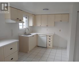 A kitchen with white cabinets and a white dishwasher.