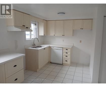 A kitchen with white cabinets and a white dishwasher.