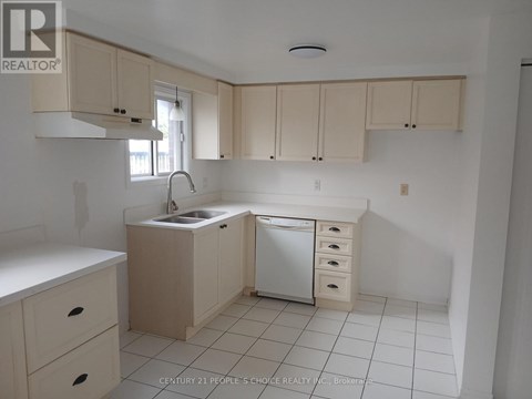 A kitchen with white cabinets and a white dishwasher.
