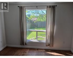 A room with a window showing a backyard.