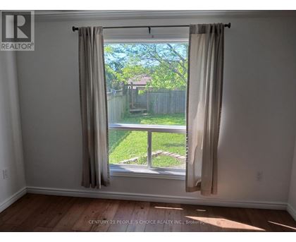 A room with a window showing a backyard.