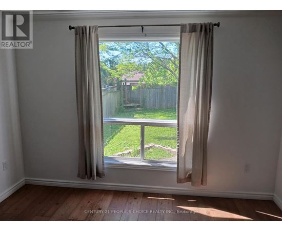 A room with a window showing a backyard.