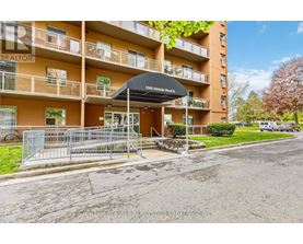 The image shows a multi-story residential building with a black awning and a sign that reads "1566 Addison St."