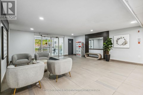 A modern living room with grey armchairs and a wooden floor.