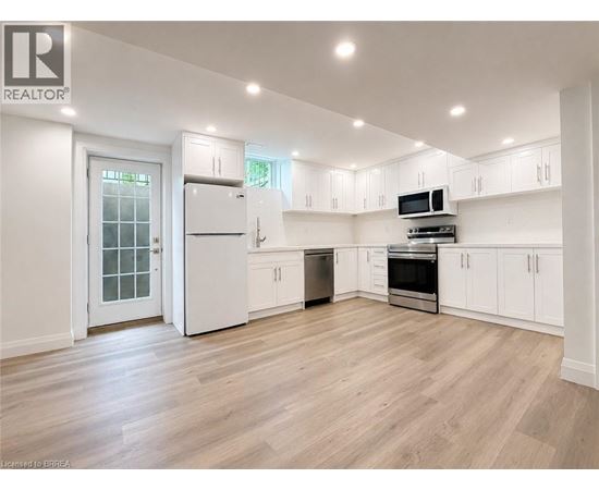 A spacious kitchen with white cabinets and appliances.