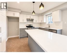 A modern kitchen with white countertops and a large island.