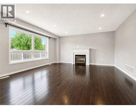 A spacious living room with a fireplace and hardwood floors.