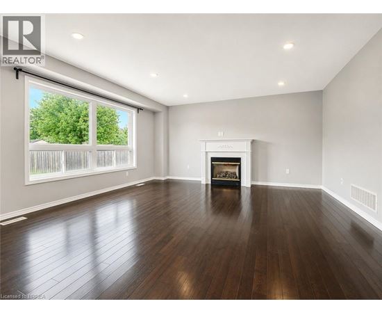 A spacious living room with a fireplace and hardwood floors.