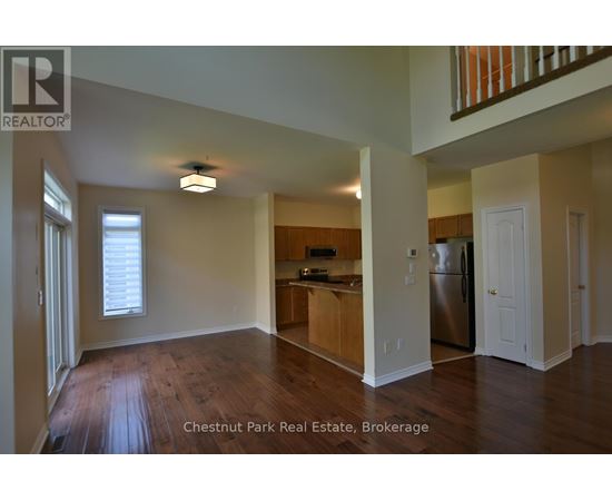 A spacious kitchen with a refrigerator, sink, and cabinets in a Chestnut Park Real Estate Brokerage property.