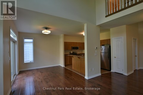 A spacious kitchen with a refrigerator, sink, and cabinets in a Chestnut Park Real Estate Brokerage property.