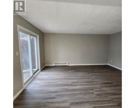 A room with wooden flooring and a sliding glass door.