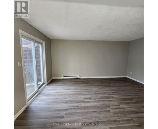 A room with wooden flooring and a sliding glass door.
