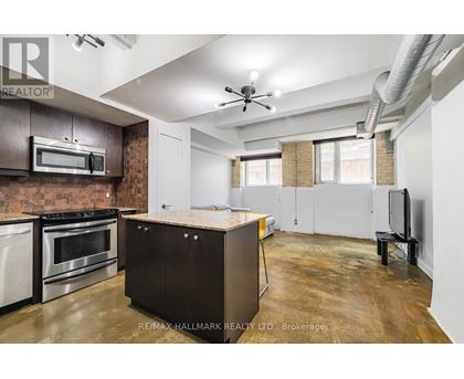 A kitchen with a brick wall and stainless steel appliances.