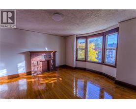 A room with a fireplace and wood flooring.