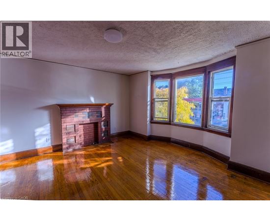 A room with a fireplace and wood flooring.