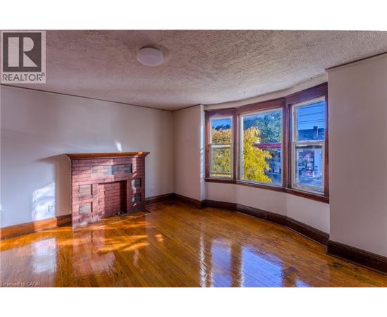 A room with a fireplace and wooden floors.