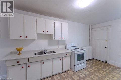 A kitchen with white cabinets and a white stove.