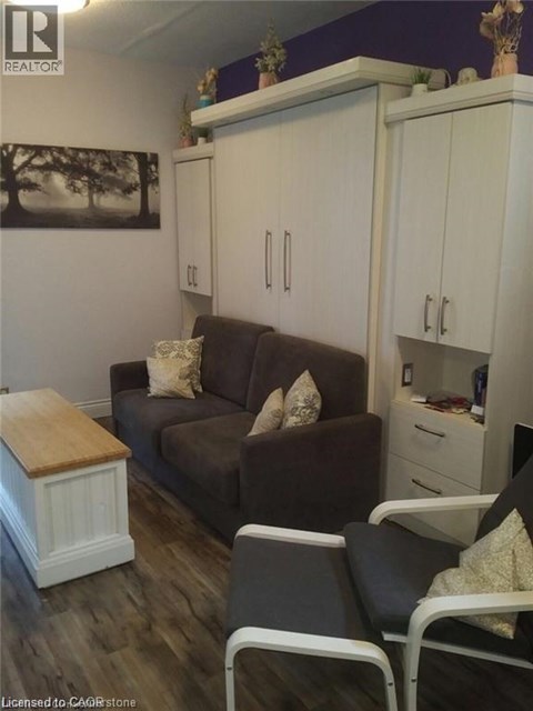 A living room with a brown couch, a wooden table, and a painting on the wall.