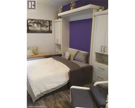 A bedroom with a bed, a couch, and a cabinet.