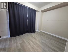 A room with a black curtain and wooden flooring.
