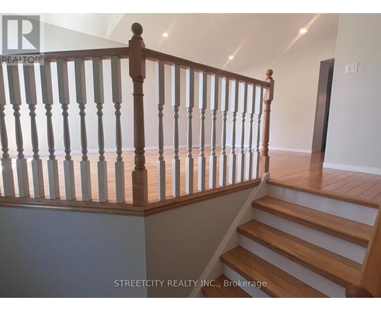 A staircase with a wooden handrail and white balusters.