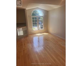 A room with wooden flooring and a large window.