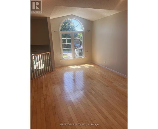 A room with wooden flooring and a large window.