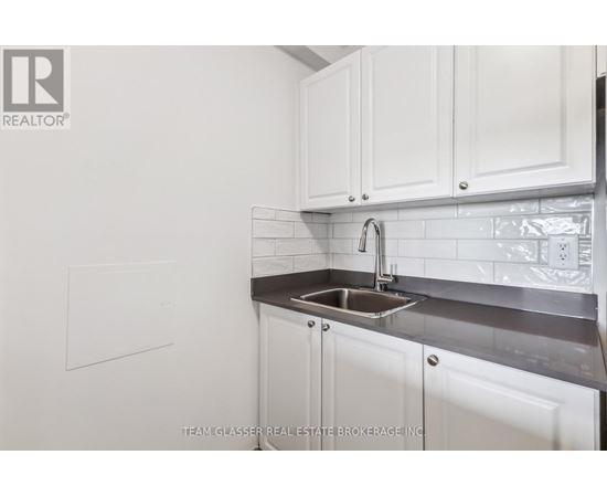 A white kitchen with a sink and cabinets.