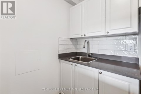 A white kitchen with a sink and cabinets.