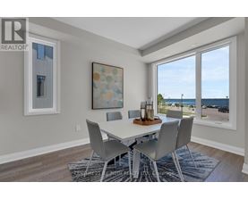 A dining room with a table and chairs and a view of the street outside.