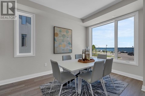 A dining room with a table and chairs and a view of the street outside.